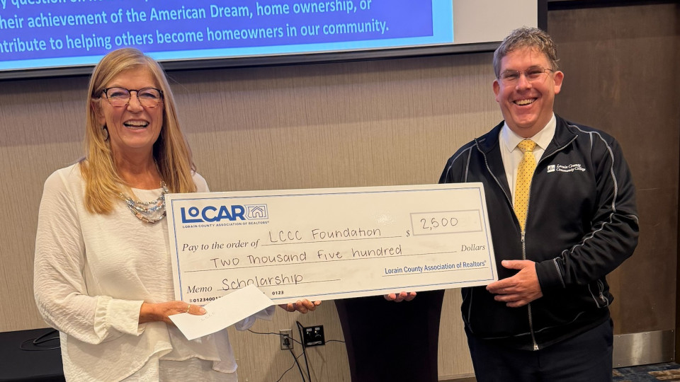 LoCAR REALTOR® Kim Guelker presents Jonathan Logue,  Director of Development for the Lorain County Community College Foundation the LoCAR Scholarship check.